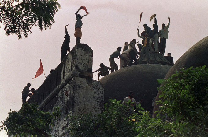 Hindus shout and wave banners as they celebrate the destruction of the 16th century Babri Mosque in Ayodhya on December 6, 1992