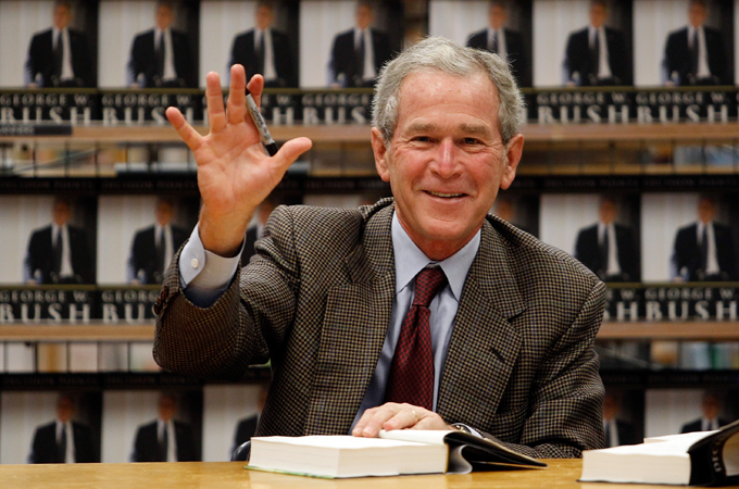 George W Bush waves at a book signing