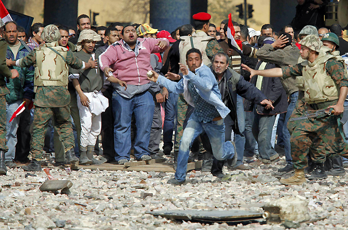 A supporter of Mubarak tries to get to opposition lines near Tahrir Square in Cairo