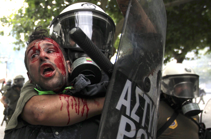 Athens riot police hold anti-austerity protester