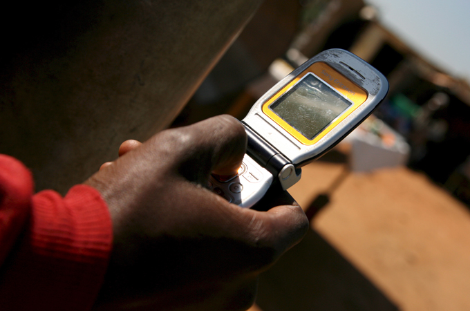 south african holding a mobile phone