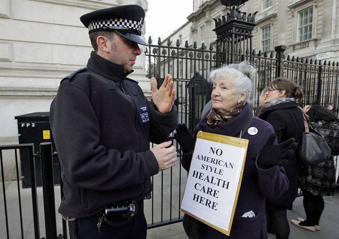 A police officer speaks to a demonstrator outside Downing Street in London February 20, 2012. Britain''s Health Secretary Andrew Lansley was heckled and jostled by demonstrators when arrived for a round table discussion on the future of the NHS, at Downing Street . REUTERS/Stefan Wermuth (BRITAIN - Tags: POLITICS HEALTH)