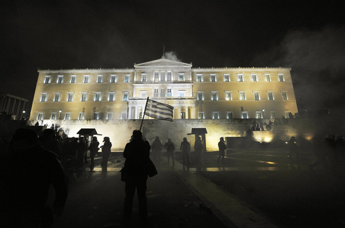 Greek protester waves flag in front of parliament