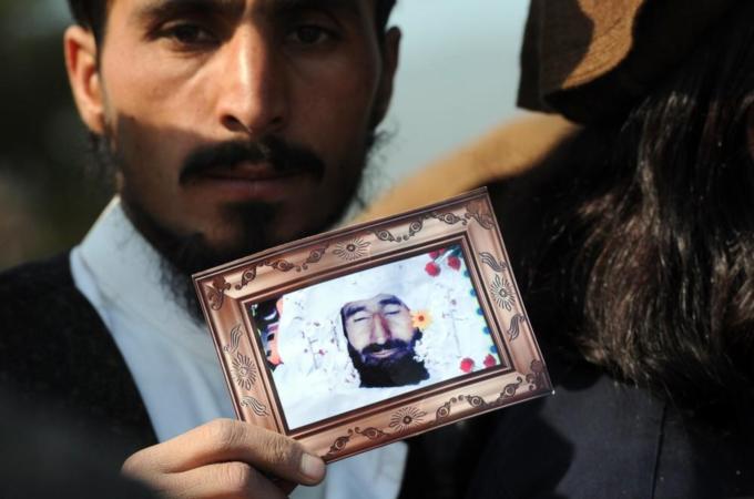 A Pakistani tribesman shows a photograph