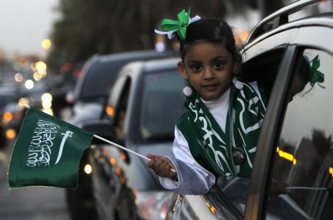 A girl waves a Saudi national flag after Saudi King Abdullah addressed the nation in Riyadh