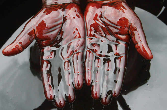 Man covers hands in crude oil during protest over Shell oil spill in Nigeria
