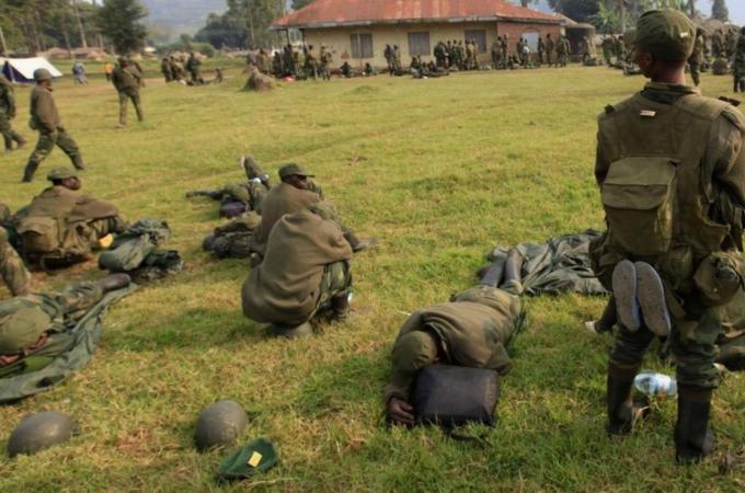 Soldiers from Democratic Republic of Congo rest in a field in Uganda border town of Kisoro