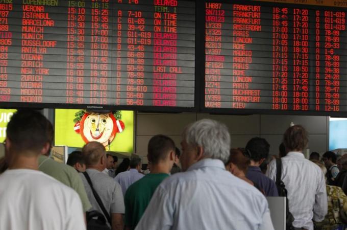 Passengers queue for security checks in front of information boards at the Ben Gurion International Airport near Tel Aviv