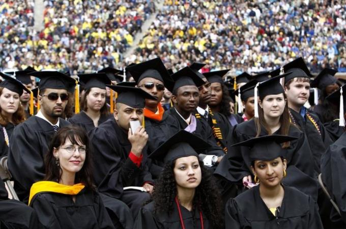 Graduating students listen to U.S. President Obama speak during commencement at the University of Michigan