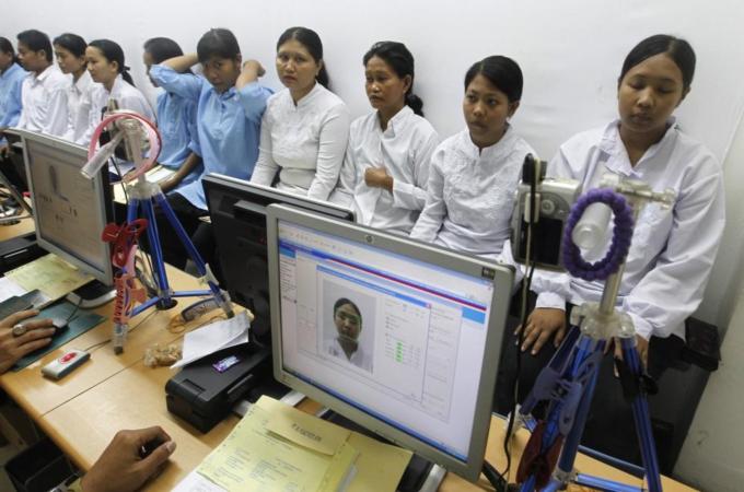 Migrant workers heading for Middle East countries have their picture taken for their passport at the immigration office in Tangerang