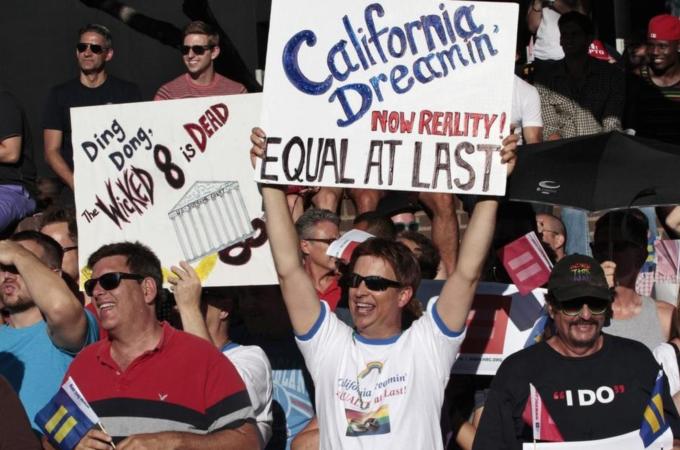 People hold signs during a community celebration for the U.S. Supreme Court ruling on California''s Proposition 8 and the federal Defense of Marriage Act, in West Hollywood