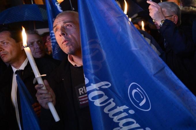 A man holds a candle as he demonstrates