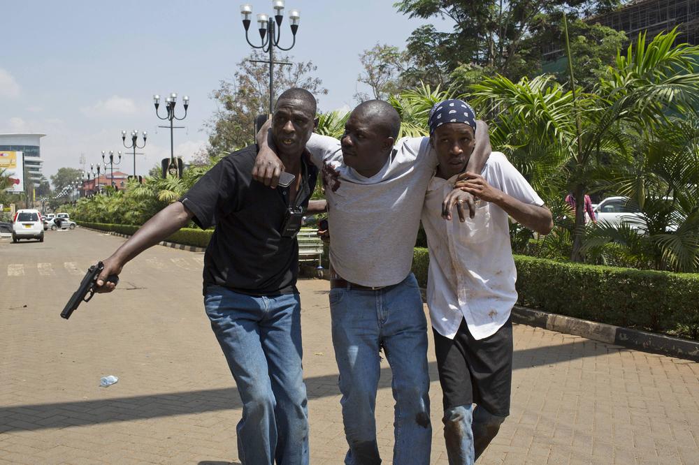 A man is helped out of Westgate Shopping Centre where gunmen went on a shooting spree, in Nairobi