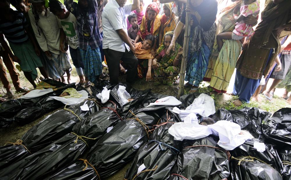 <p>Villagers watch as the dead bodies of the victims are brought for burial in Narayanguri village in Baksa district, about 200km from Guwahati, the capital of Assam state.</p>