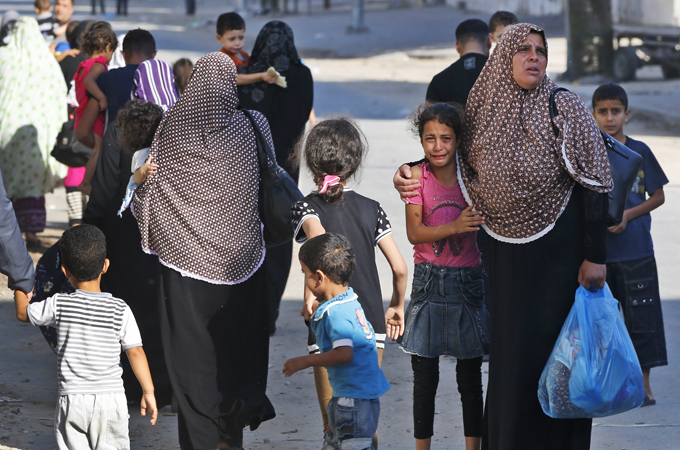 Residents Zeitoun were seen walking in the streets, carrying their belongings as they tried to evacuate [AP]