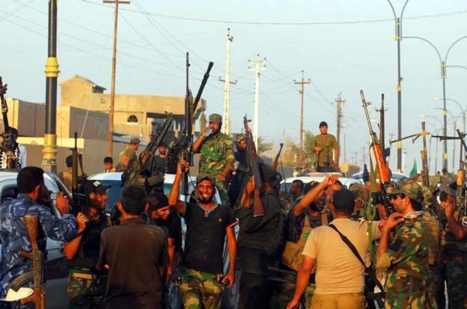 Members of an Iraqi Shiite militia celebrate after they retook 35 towns from the Islamic State group [EPA]