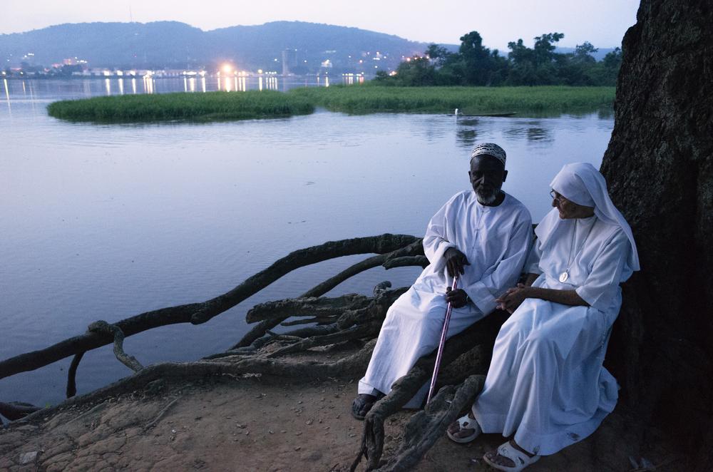 <p>Imam Moussa Bawa, 72, and Sister Maria Concetta, 80, converse on the banks of the Oubangi River in Zongo, DRC. The two religious leaders attempt to heal the wounds that have divided the Christian and Muslim communities in Central Africa Republic. </p>