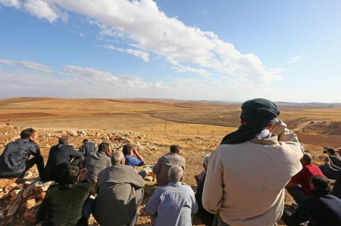Turkish citizens watch the clashes between Kurdish troops and ISIL in southeastern Turkey [Getty Image]