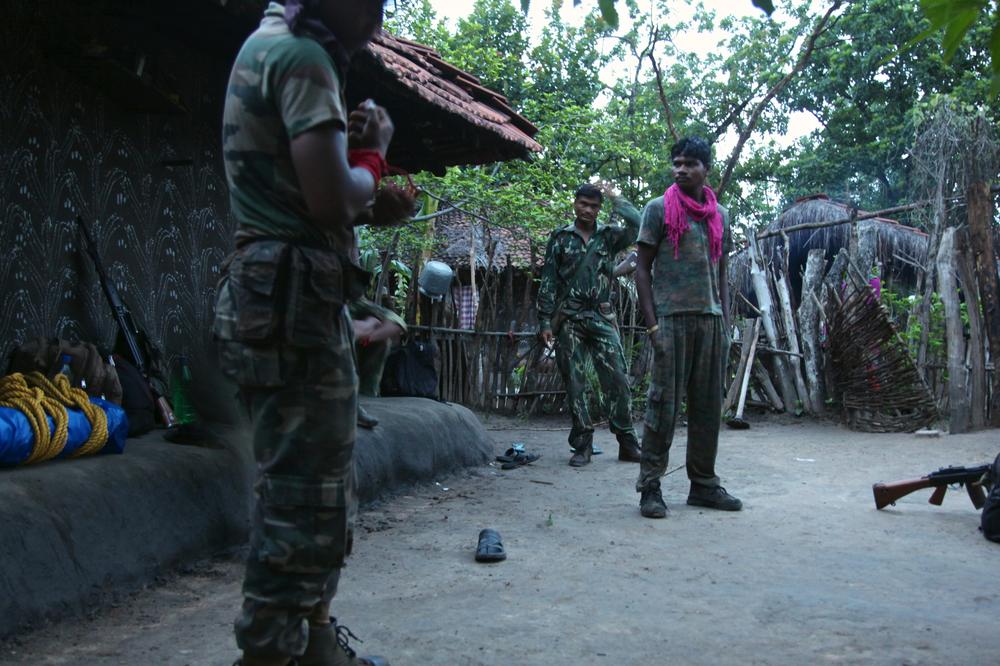 <p>Camped overnight at Konjed village, policemen prepare to resume their patrol. They use red armbands as identification to prevent friendly fire.</p>