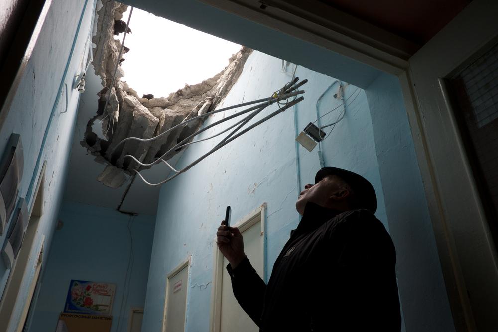 <p>A staff member at School 61 in Donetsk checks the damaged roof hours after it was hit by artillery fire, reportedly by the Ukrainian National Guard, during fighting for the control of the city(***)s airport.</p>