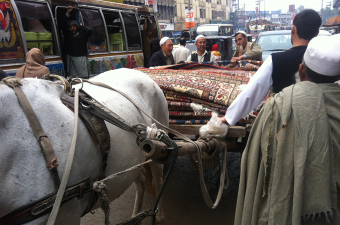 A cart full of Ghazni rugs arrives from the tribal areas [Riyaz Bhat/Al Jazeera]