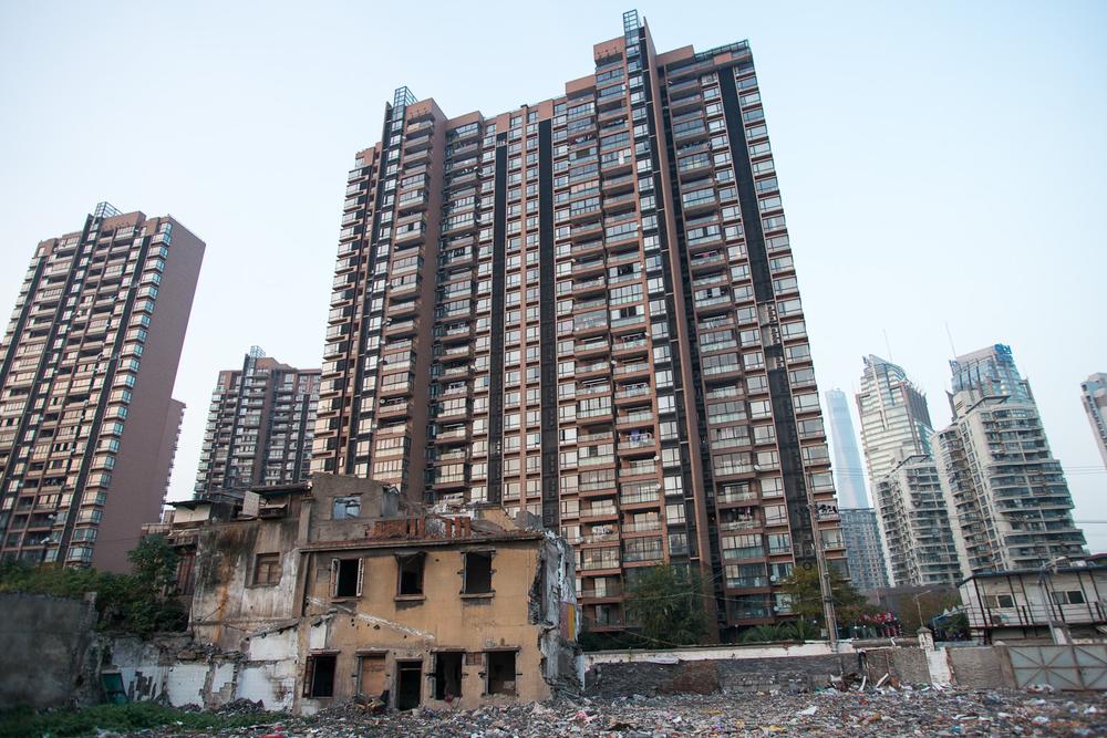 <p>A section of a colonial-era building stands on the edge of an old residential block that has been cleared to make way for more high-rise development, such as those seen in the background. </p>
