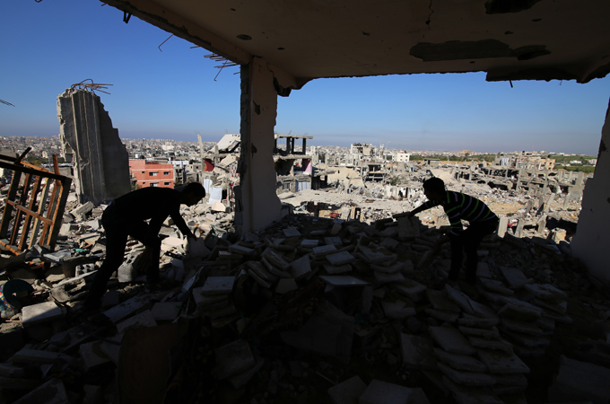 Residents comb through the rubble of a demolished home in Shujayea, Gaza [Hatem Omar/Al Jazeera]