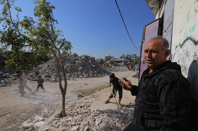 Children in Shujayea play amongst piles of shattered cement and debris from fallen homes [Hatem Omar/Al Jazeera]