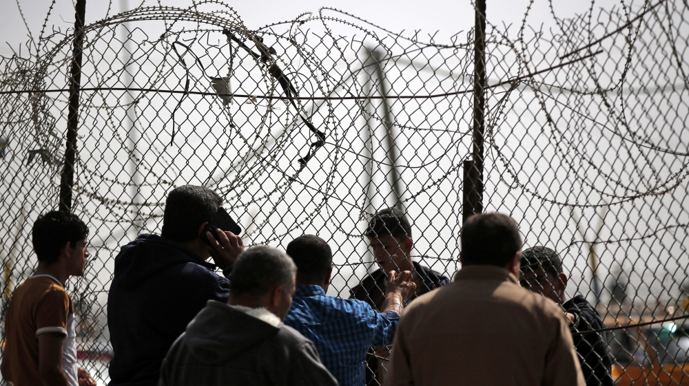Palestinians wait to cross the border between the Gaza Strip and Egypt