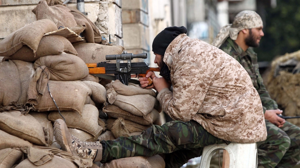 A Libyan soldier monitors a street from his sniper nest in Benghazi [AFP]