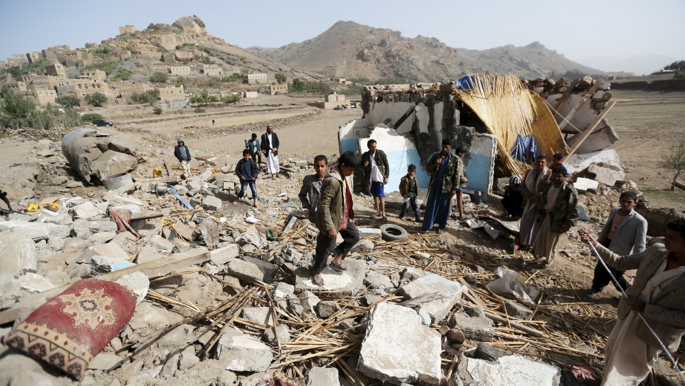 People gather on the wreckage of a house destroyed by an air strike in the Bait Rejal village west of Yemen''s capital Sanaa