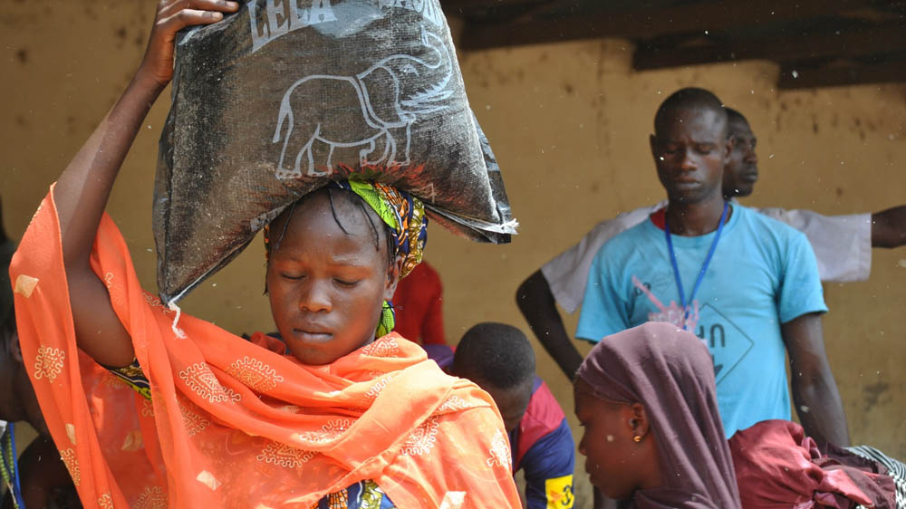 Each woman at the food distribution centre receives 25kg of maize or 25kg of shorgum and 200 naira ($1) [Fragkiska Megaloudi/Al Jazeera]