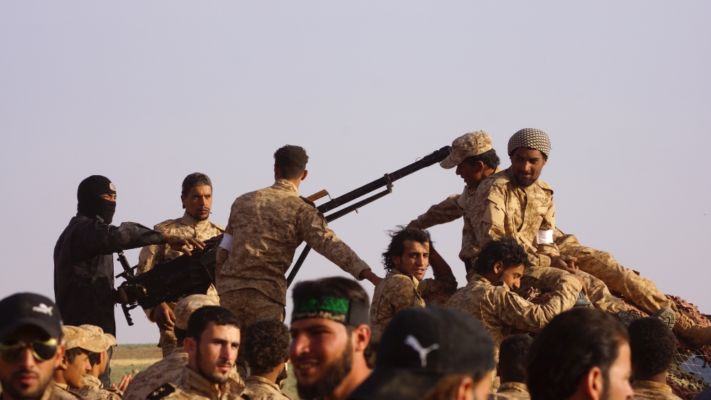 Armed Syrian rebels during a parade after completing their training in Daraa [Getty]