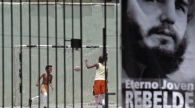 Children play football behind a picture of Cuba's former president Fidel Castro in Havana [REUTERS]