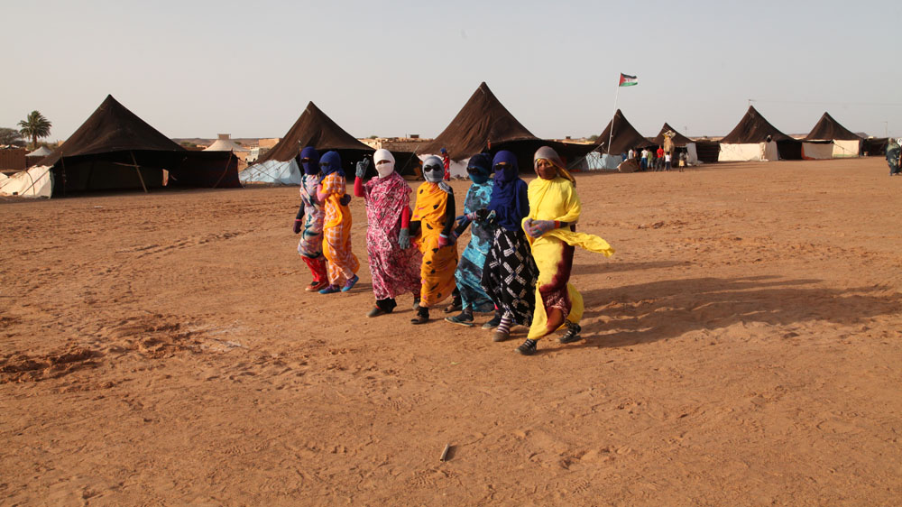 Women protect themselves from the searing sun in 'The Devil's Garden' area [Hannah McNeish/Al Jazeera]