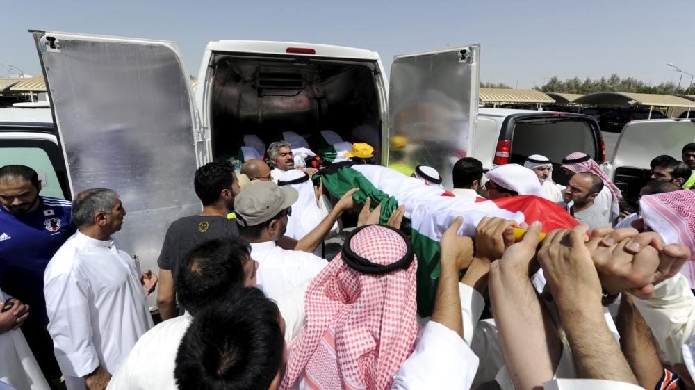 Bodies of the victims of Friday''s bombing are transferred to vehicles to be transported to Karbala, Iraq, at Al Jafariya cemetery in Suleibikhat, Kuwait