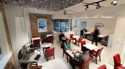Veteran identification tags, called dog tags, hang as a chandelier at the Dog Tag Bakery run by US veterans of war [Al Jazeera, Eric Taylor]