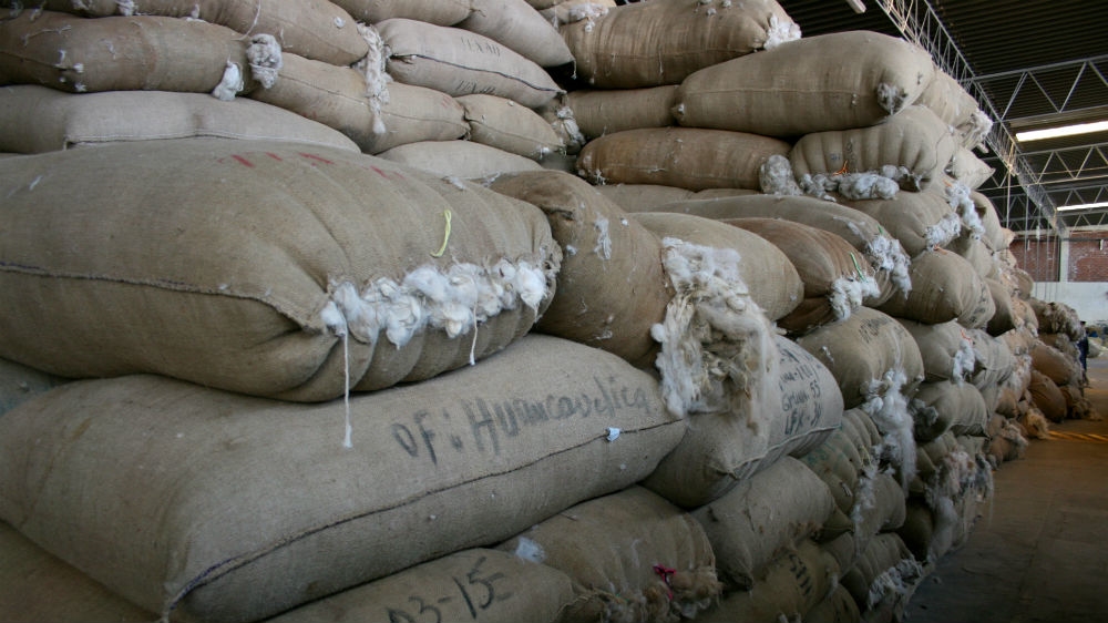 Burlaps of alpaca wool sent from all over Peru's mountain regions lie in a warehouse in Arequipa [Alex Pashley/Al Jazeera] 