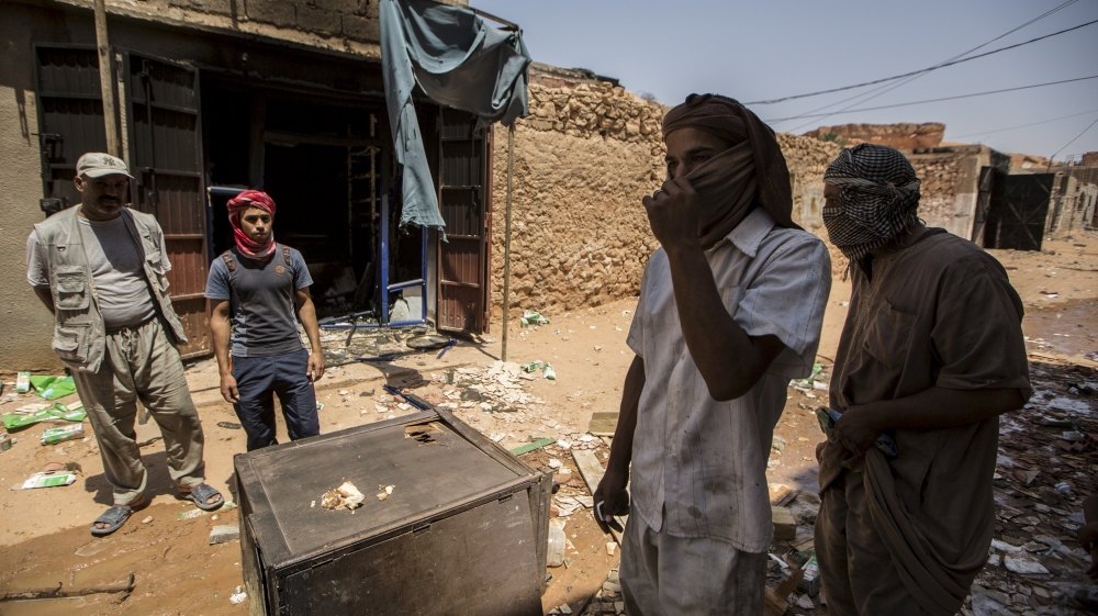 Arab people stand near a damaged shop after clashes between Arabs and Mozabits in Guerrara near Ghardaia
