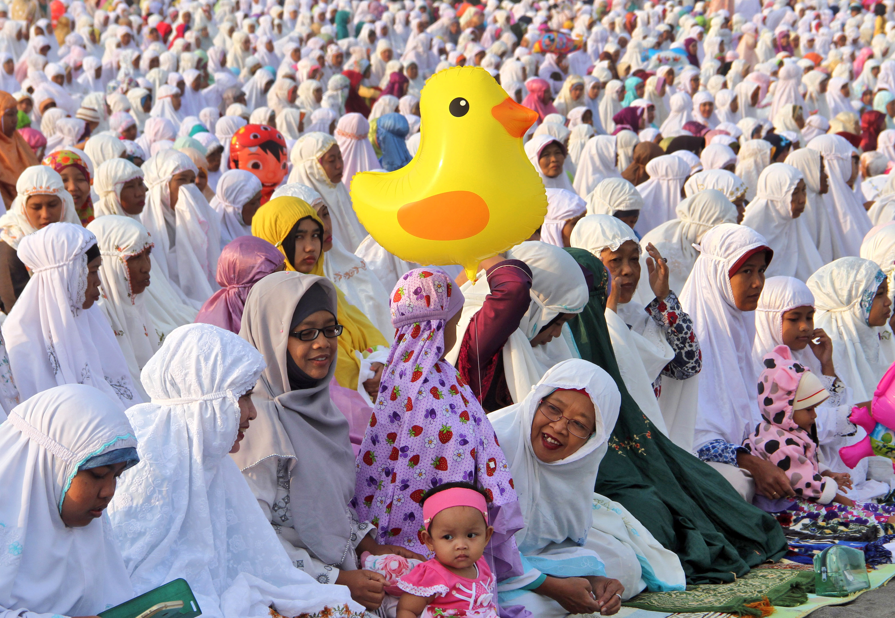 Muslim women attend an Eid al-Fitr prayer marking the end of the holy fasting month of Ramadan at Parangkusumo beach in Yogyakarta, Indonesia