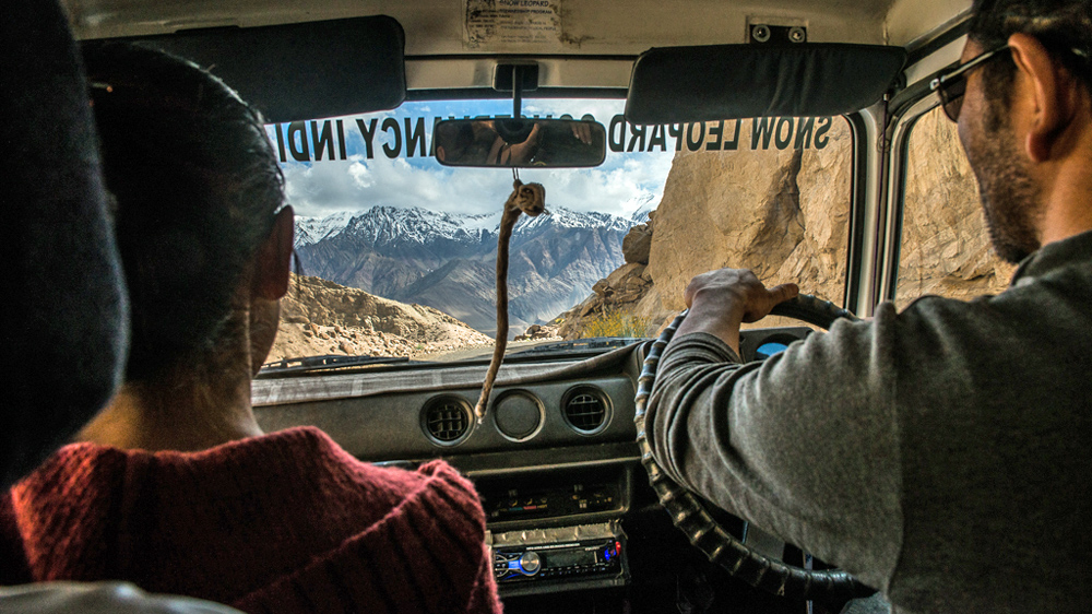 The director of the Snow Leopard Conservancy India Trust (SLC-IT), a local NGO that works towards conservation of snow leopards, Tsewang Namgail drives through mountain roads to reach remote populations [F elix Gaedtke/NowHere Media /Al Jazeera]