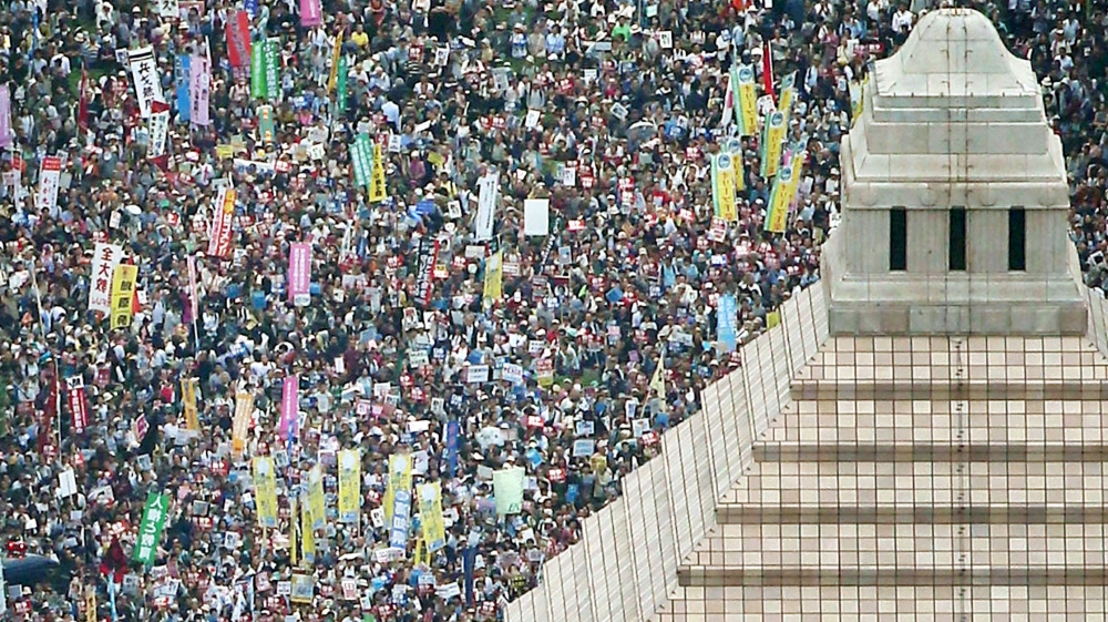 People hold placards and shout slogans as they gather to protest against Japan''s Prime Minister Shinzo Abe''s security bill outside the parliament in Tokyo