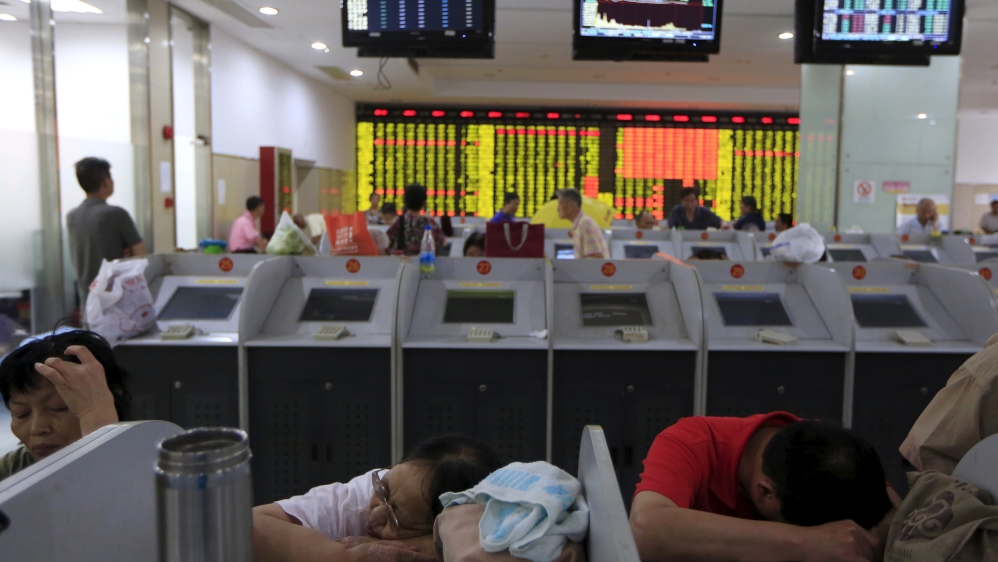 Investors rest in front at computer screens at a brokerage in Shanghai