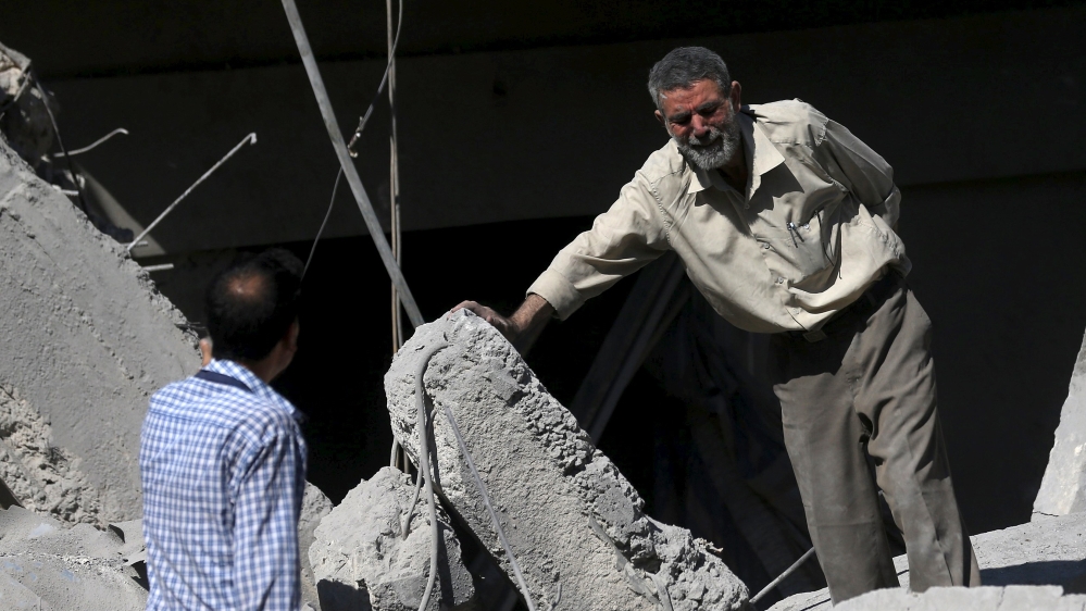 A man reacts amid rubble caused by what activists said was barrel bombs dropped by government forces in Douma [Reuters]