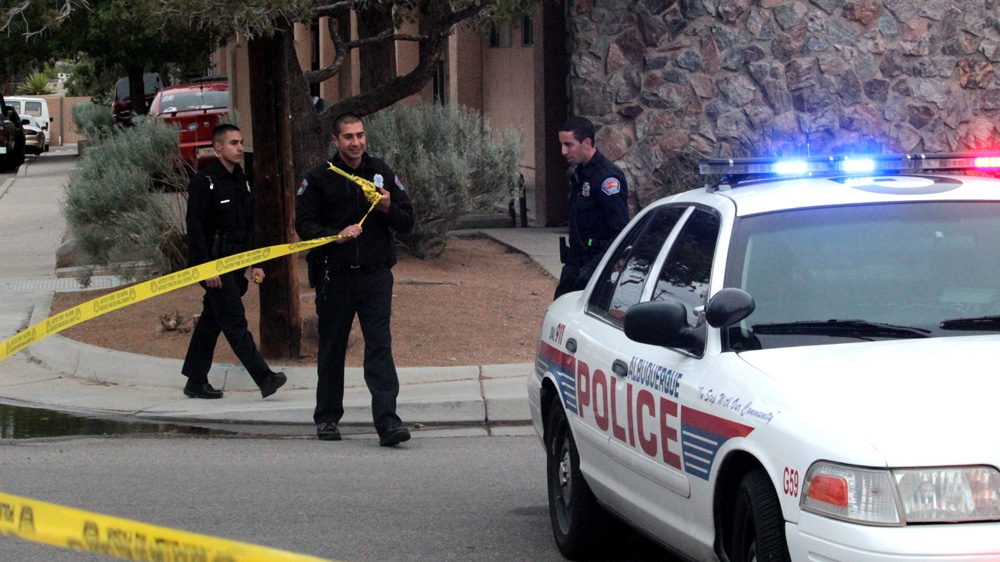 An officer removes crime scene tape after a police action in Albuquerque in May 2015. After surrounding an apartment with guns drawn for several hours, police realised the suspect was not there [Andy Beale/Al Jazeera]