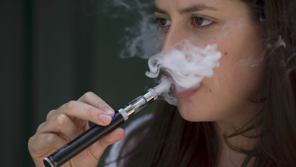 A woman smokes an electronic cigarette in London