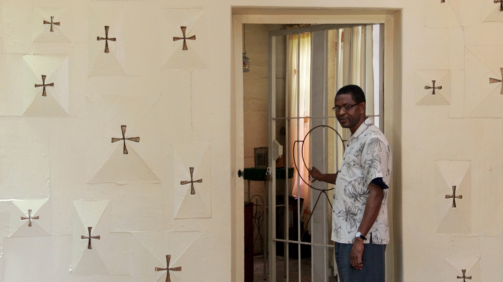 Father Cletus Nwabuzo walks into the service vestry where the brothers have now installed steel frame doors [Femke van Zeijl/Al Jazeera]