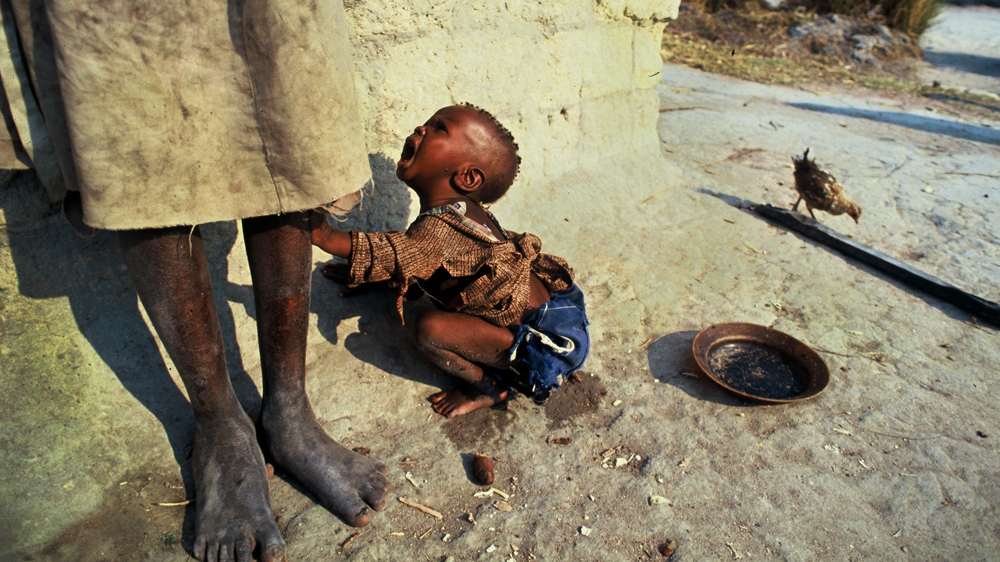 A sick child cries to be picked up during the civil war in Quito, Angola. No matter how many times I photographed scenes of poverty and desperation like this one, I never failed to be confronted by the pathos of it. 1994 [Jack Picone] 
