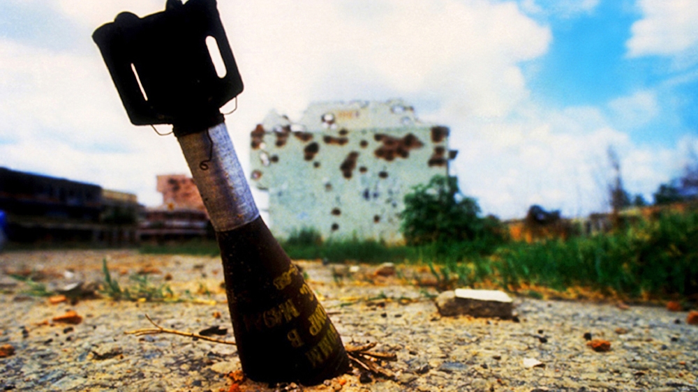 Unexploded ordnance in Quito, Angola. In hindsight, I don't know what I was thinking lying on the ground beside an unexploded bomb. 1993 [Jack Picone] 