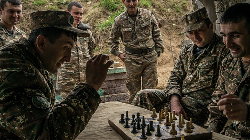 Members of the armed forces of Nagorno-Karabakh play checkers using a chess set at their post along the line of contact with Azerbaijani forces [Getty]